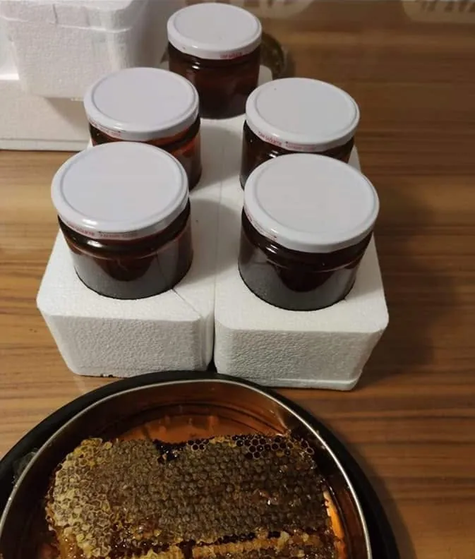 Köpük ara bölmelere yerleştirilmiş kavanozlar ve tepside petek